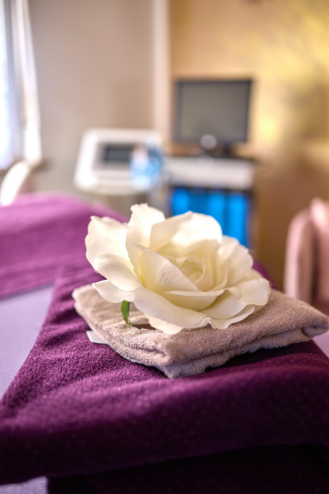 Weiße Rose auf Handtüchern im Behandlungsraum von Jasminkosmetik